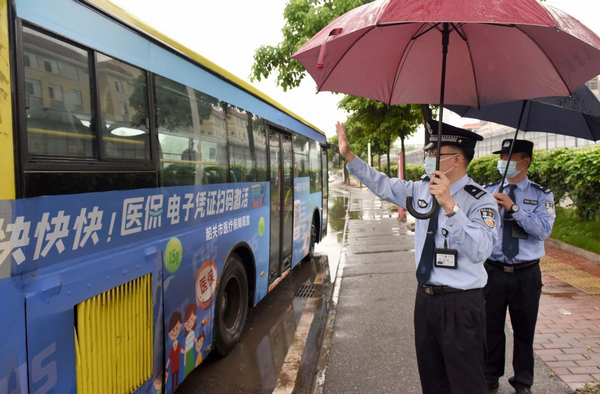 武江监狱警察余华勋将刑满释放人员刘某送上公交车,双方挥手告别