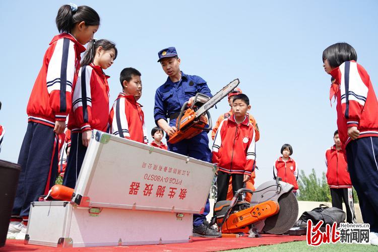2021年5月11日,河北省临城县消防队员向岗西小学学生讲解消防设备的使用方法。通讯员王永周摄影报道