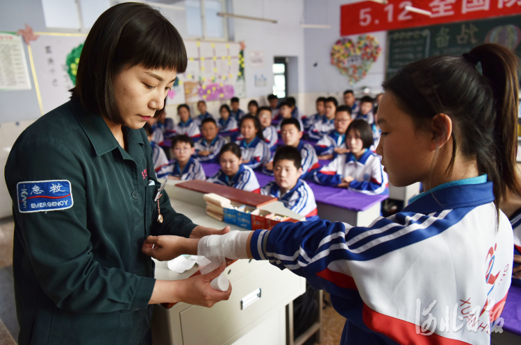 2021年5月11日,宣钢医院急诊科护师为学生演示救护包扎方法。