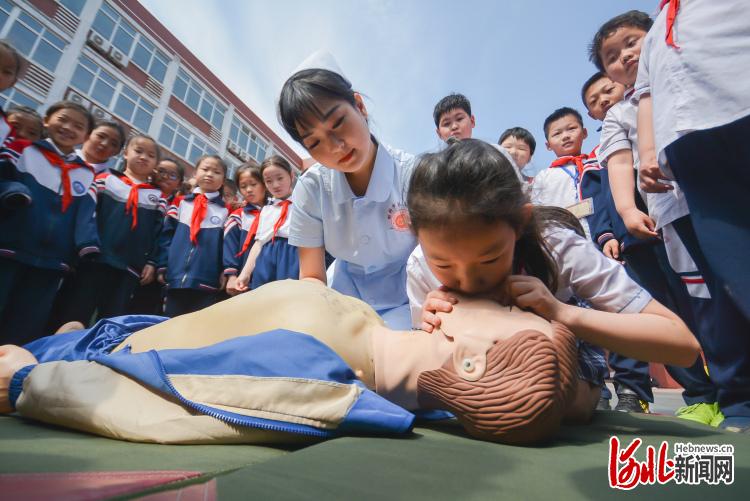 2021年5月11日,河北省邯郸市邯山区实验小学学生在邯郸市第三医院医护人员指导下学习心肺复苏。