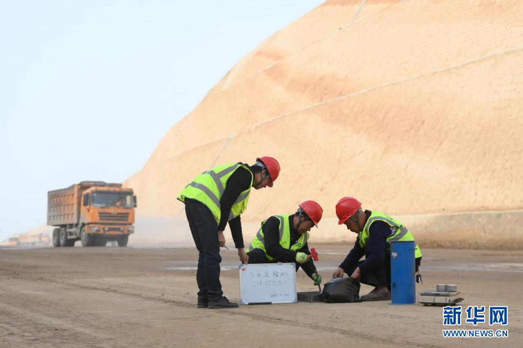 工人在国道209线吕梁新城区公路改线项目CFB炉渣土路床铺筑段进行压实度检测。新华网 发（刘亮亮 摄）