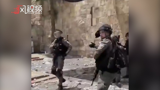 以色列安全部队士兵试图向人群扔震爆弹，被记者拍到后退缩了
