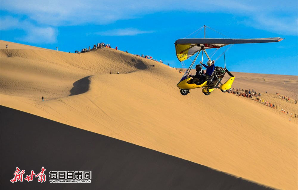 5月6日，游客乘坐滑翔机鸟瞰敦煌大漠风光。