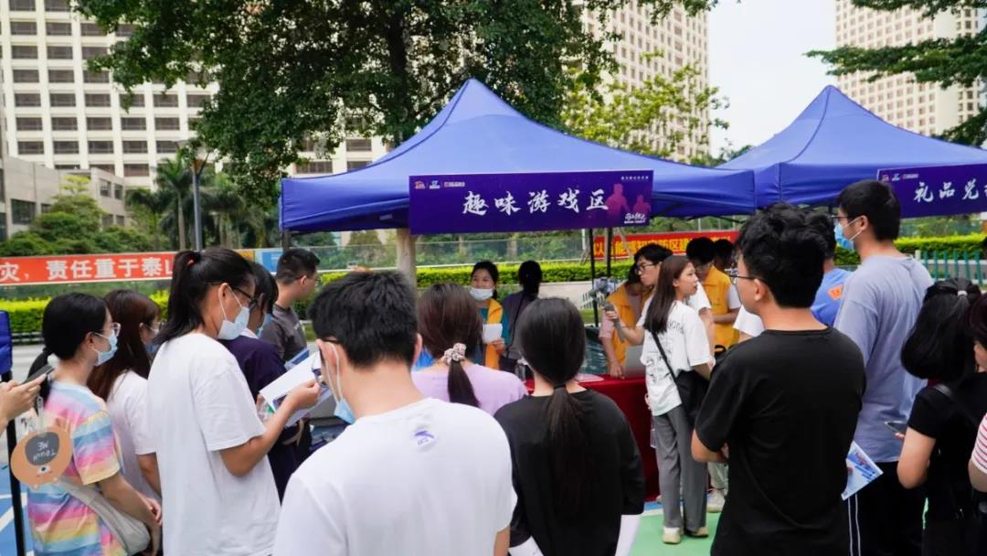 青年朋友们在咨询服务摊位互动