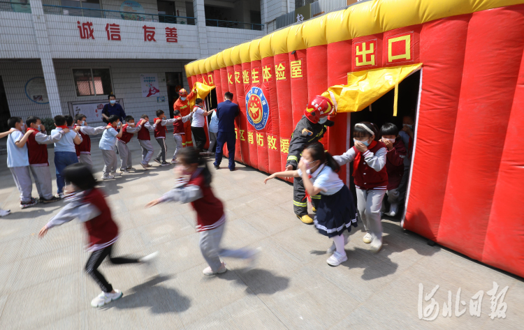 2021年5月11日,河北省石家庄市南马路小学学生在消防员指导下演练火灾逃生。