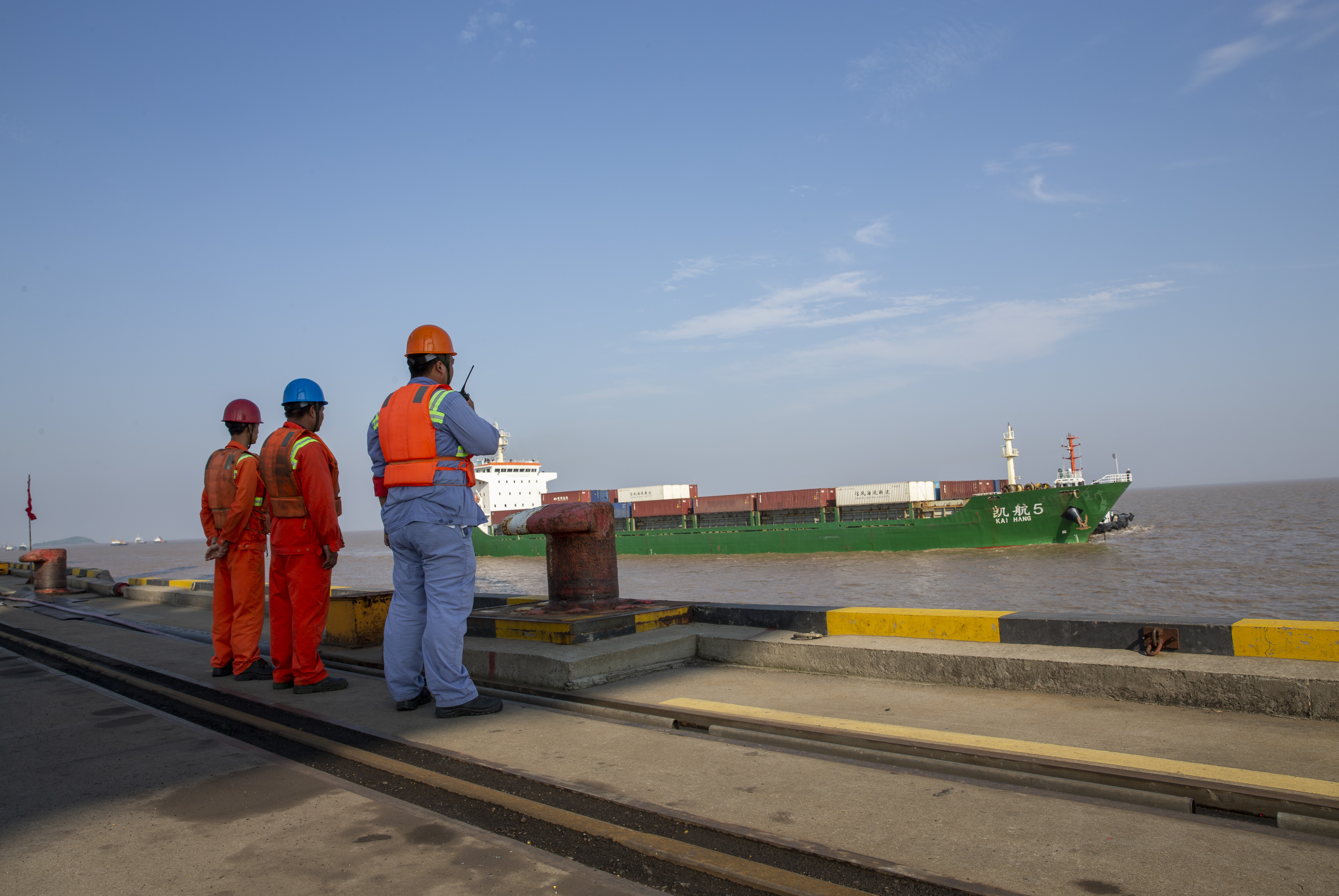 一艘集装箱货轮正准备停靠在码头,港口工人进行指挥. 刘玉宝 摄