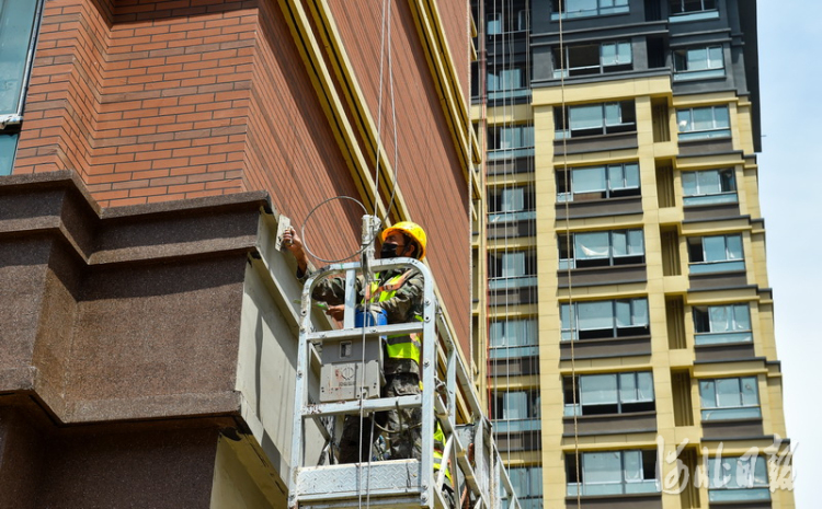 2021年5月17日,雄安新区容东片区中建三局G2安置房项目,建设者在进行楼宇外墙面作业。