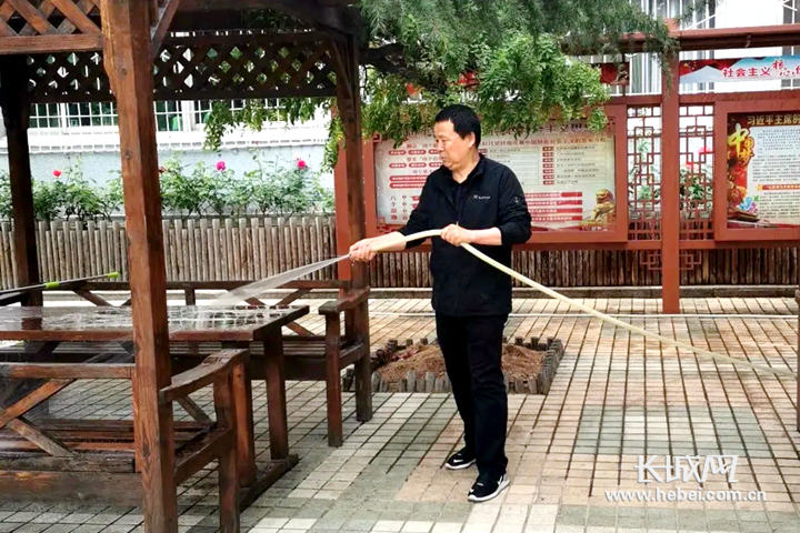 开滦第一中学教辅第一党支部的党员干部职工在校园内进行清洗清扫工作。