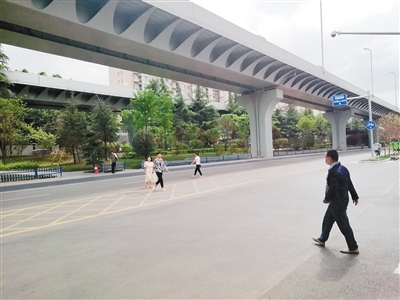 建工路和火炬路交叉口，市民去往街心花园须横穿马路。 （记者 李东峰 摄）