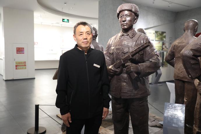 图为赵连河与其父亲赵旺塑像合影