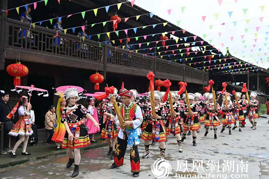 图为黄畲侗寨里欢乐的芦笙迎宾队伍