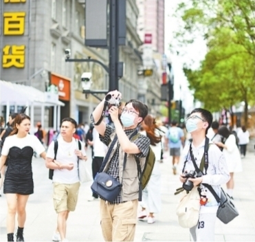 5月16日，江汉路步行街上，年轻人拍照留影。记者詹松 摄
