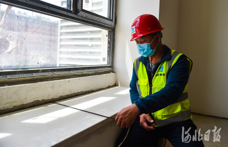 2021年5月17日,雄安新区容东片区中建三局G2安置房项目,三工区综合工长涂德宝在检测窗台面安装情况。