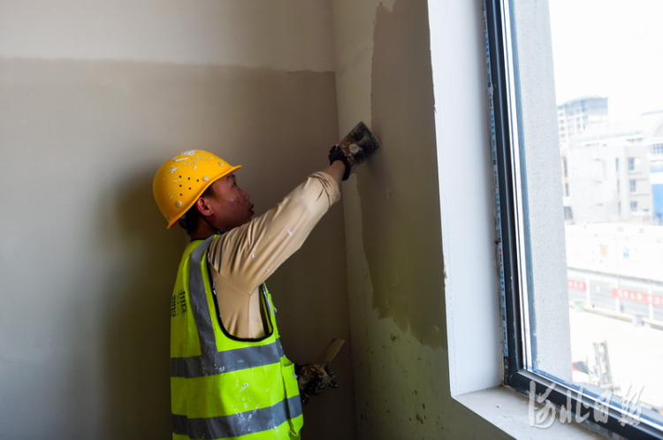 2021年5月17日,雄安新区容东片区中建三局G2安置房项目,建设者在进行楼宇内墙面作业。