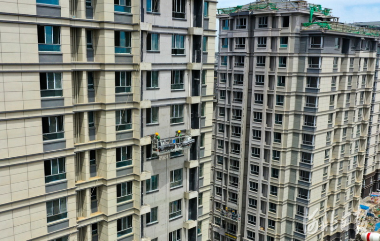 2021年5月17日,雄安新区容东片区中建三局G2安置房项目,建设者在进行楼宇外墙面作业。