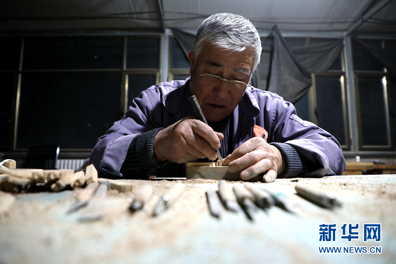 图为团队成员李俊林在雕刻雀替