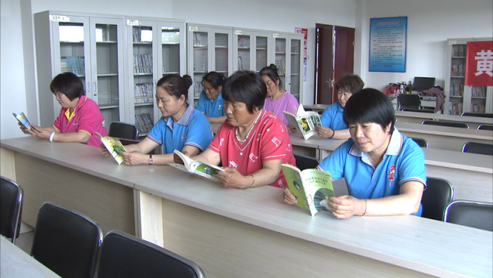 图为黄土庄镇村民在图书室阅读书籍