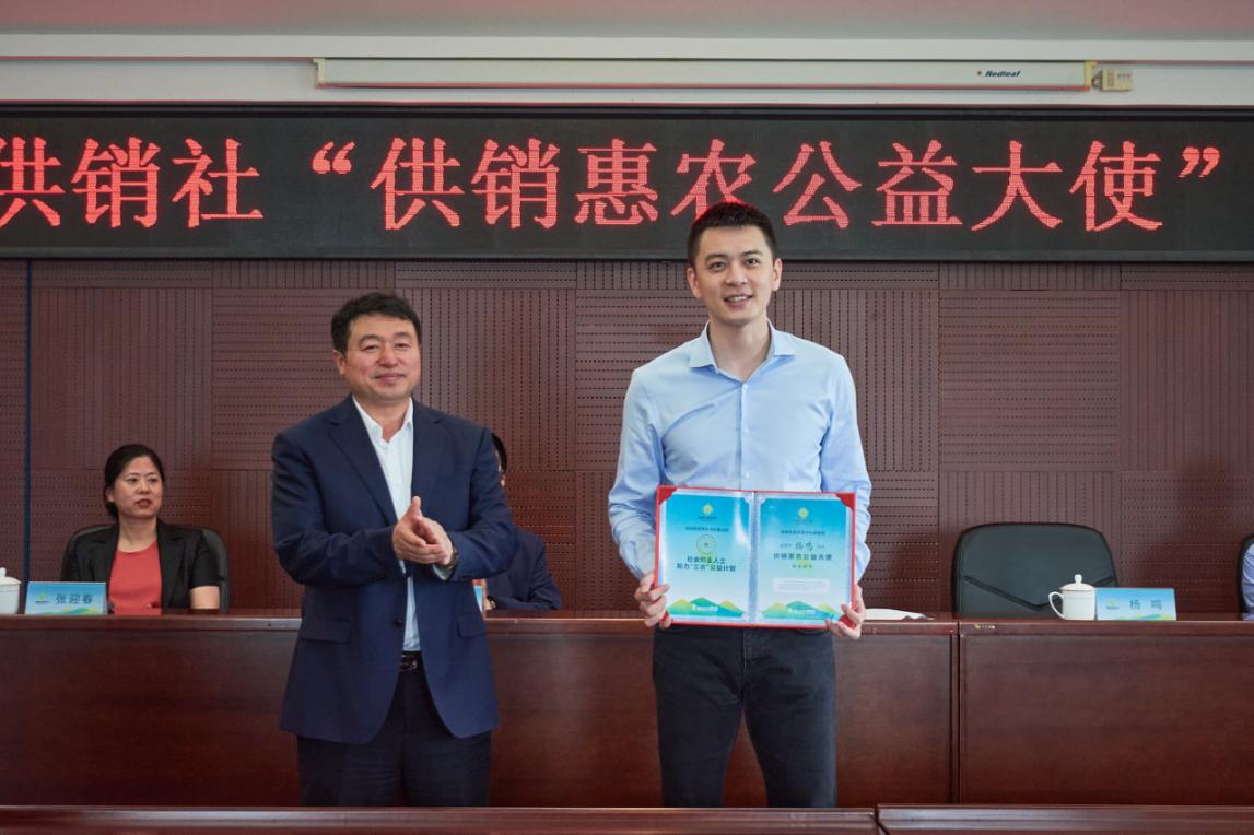 沈阳市供销合作社联合社主任孔德树(左)为杨鸣颁发"供销惠农公益大使"
