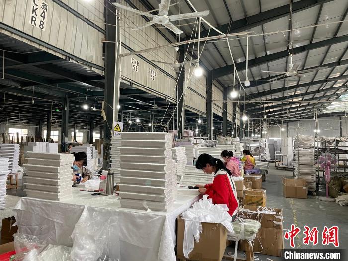 图为，庄寨镇一工厂工人正在加工棺木。　孙宏瑗 摄