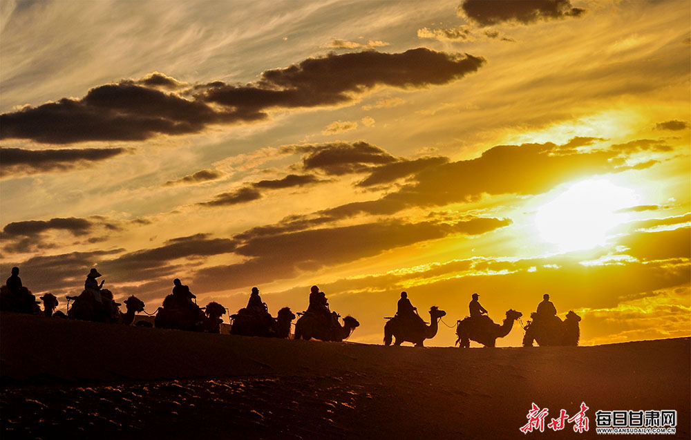敦煌大漠渲染夕阳美 游人醉听驼铃声