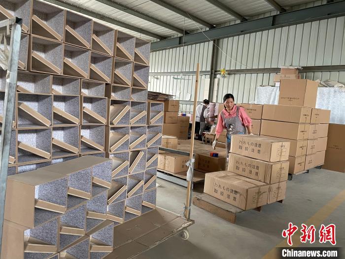 图为，庄寨镇一工厂工人正在打包棺木。　孙宏瑗 摄