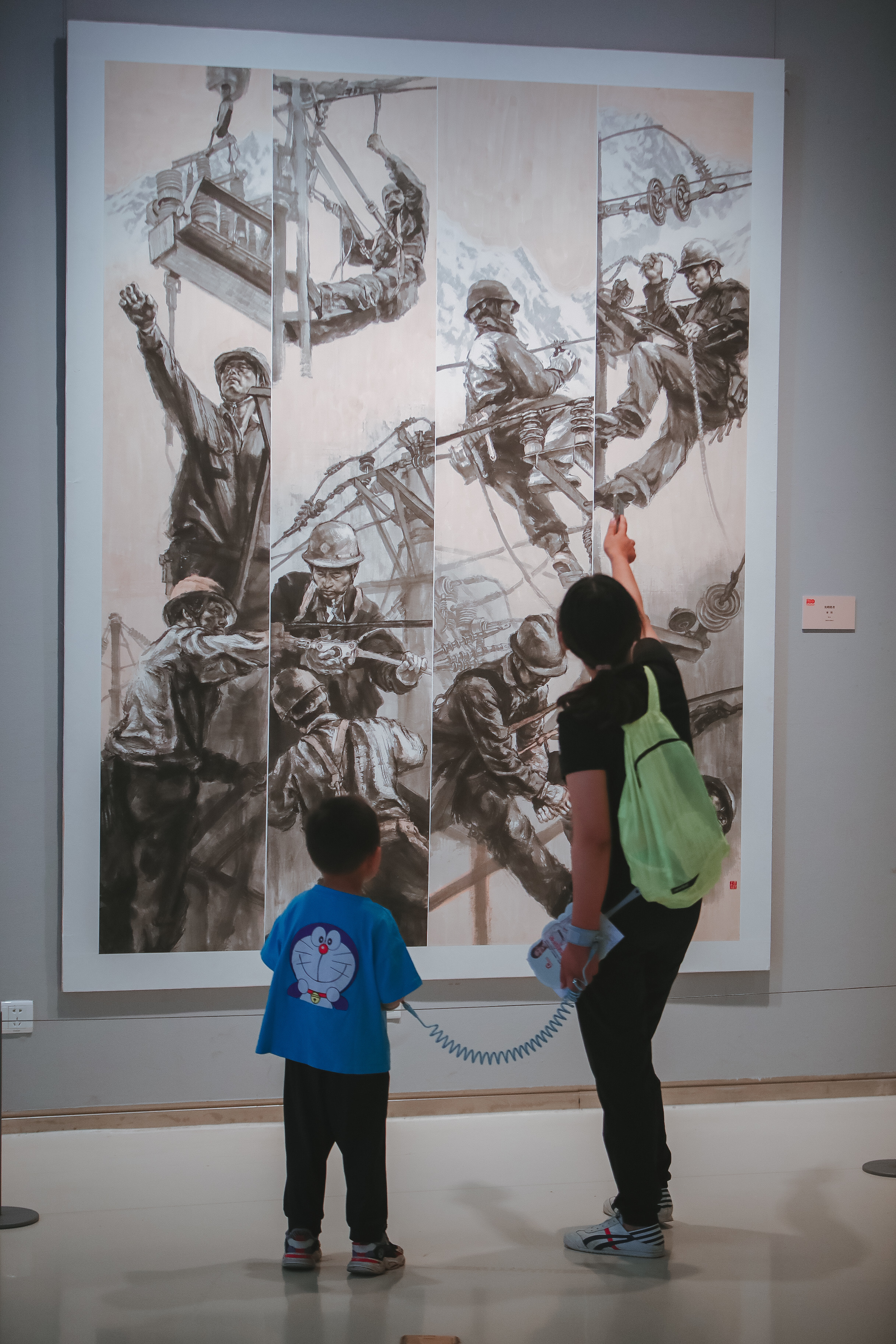 家长带领孩子观赏并讲解美术作品