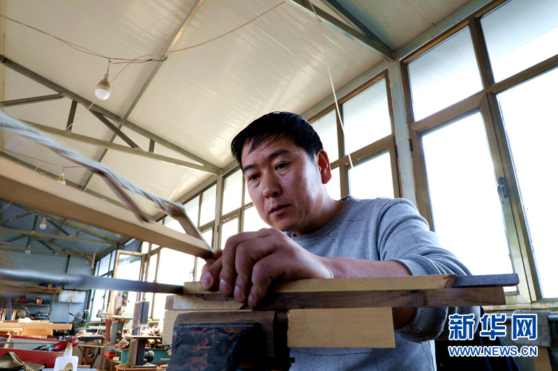 图为团队成员丁民泉在锯榫头