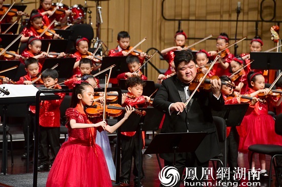 特邀湖南音协弦乐学会副会长黄中意先生与百名琴童演奏《唱支山歌给党听》