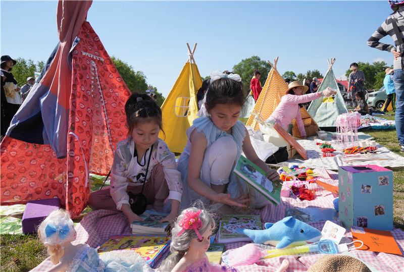 5月29日,在秦皇島市北戴河村藝術市集跳蚤市場,小朋友整理準備出售的