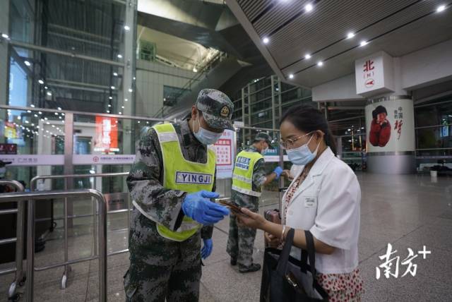 广州南站进站旅客展示“健康码”绿码以及72小时内核酸检测阴性证明。石磊 董天健 摄
