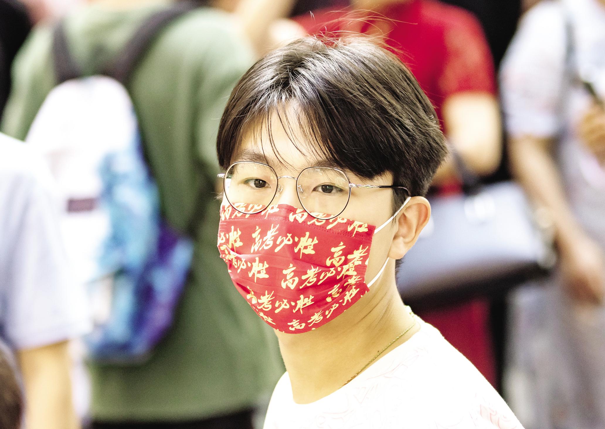 6月7日，武汉市第二中学考点，一名考生戴着“高考必胜”字样的口罩走进考场。 （湖北日报全媒记者 柯皓 摄）