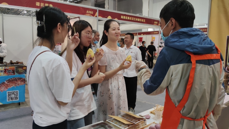 游客在非遗美食展销区品尝美食