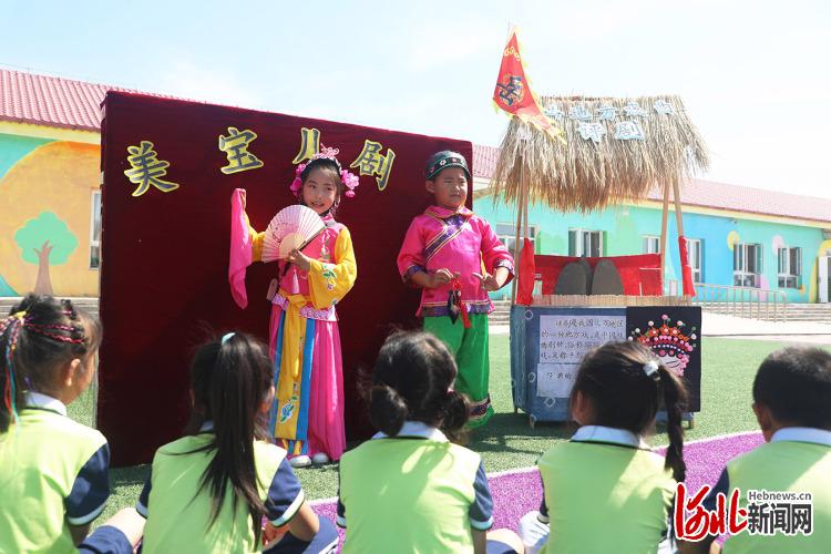 2021年6月11日，在河北省唐山市丰润区白官屯镇燕子河幼儿园“非遗大集”上，小朋友们在观看评剧《花为媒》选段。当日，河北省唐山市丰润区白官屯镇燕子河幼儿园开展“赶非遗大集，品非遗魅力”活动，将皮影、评剧、剪纸等我国非物质文化遗产项目进行展示，吸引了众多小朋友前来“赶集”，感受非遗文化的魅力。通讯员 朱大勇 摄影报道