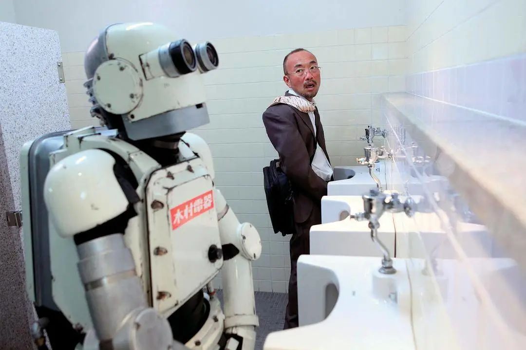 伪装机器人的大爷上厕所，引起了周围人的震惊. 图片来自：《机器人大爷》
