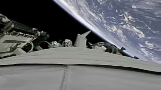 神舟十二号与地球同框 航天员舱内“玩笔”状态不错