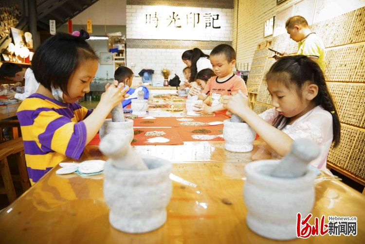 图为孩子们在亲手体验香囊制作过程。