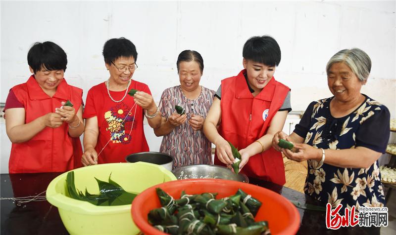2021年6月14日，河北省邢台市南和区贾宋镇志愿者和岳村的老人一起包粽子。河北日报记者赵永辉摄影报道