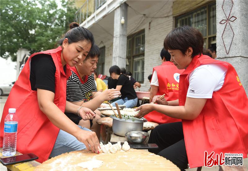 2021年6月14日，河北省邢台市南和区贾宋镇岳村志愿者为老人包饺子。河北日报记者赵永辉摄影报道