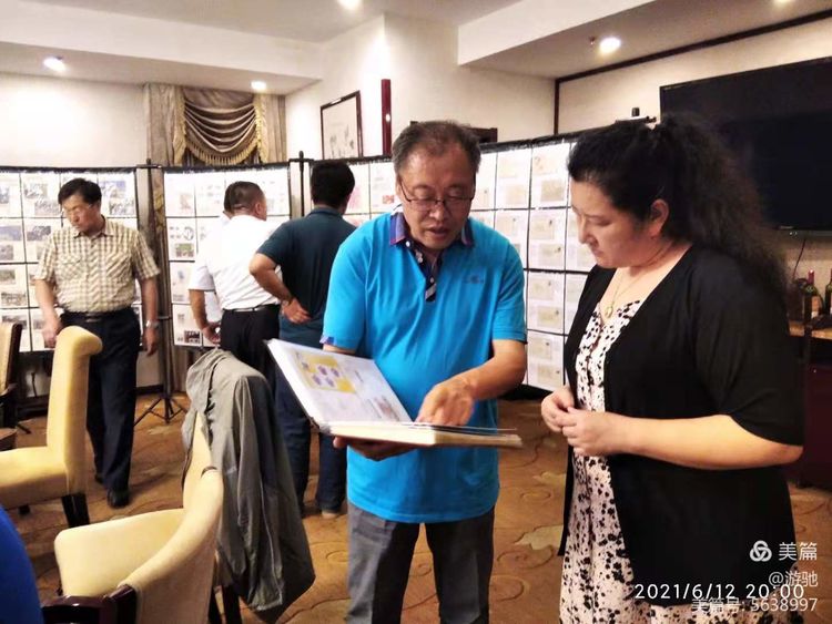 集邮专业委员会副主任汪心杰（左）与协会秘书长杨晓岩交流收藏邮品。