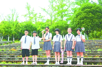 小学生以阶梯“花海”为背景，拍摄毕业照。