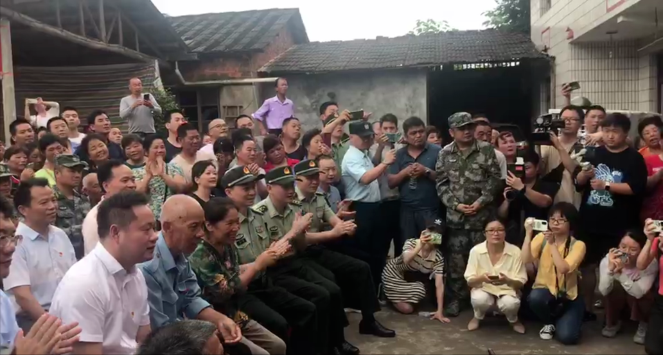 亲朋好友和军地领导围坐在汤家小院收看直播盛况