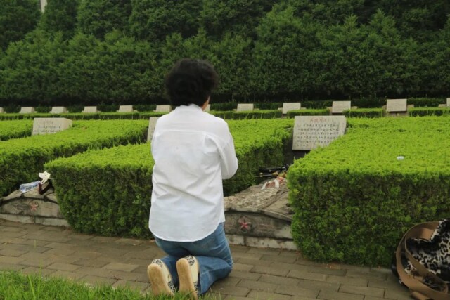 吴强烈士的后人在墓前祭奠（6月9日摄）。采访对象供图