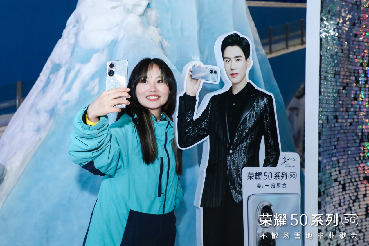 (用户现场使用荣耀50系列与代言人龚俊人形立牌合影)