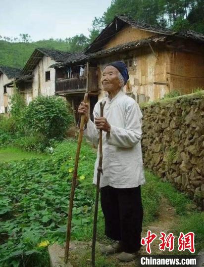 图为池煜华老人站在老屋前。　兴国县委宣传部 摄