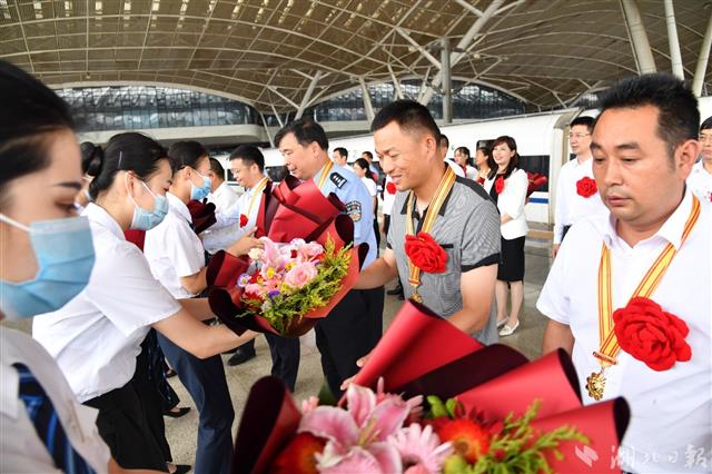 7月2日中午，受邀赴北京出席庆祝中国共产党成立100周年大会的湖北代表，乘坐高铁载誉回到武汉，受到热烈欢迎。 （湖北日报全媒记者 魏铼 摄）