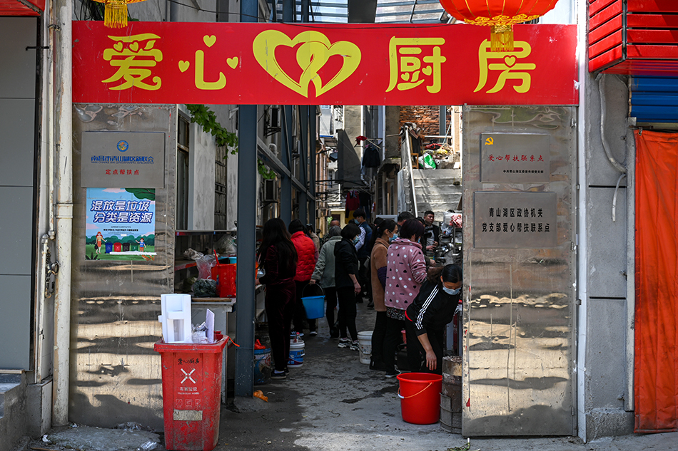 2021年3月25日，南昌，病人家属在“爱心厨房”的灶台上做饭菜。