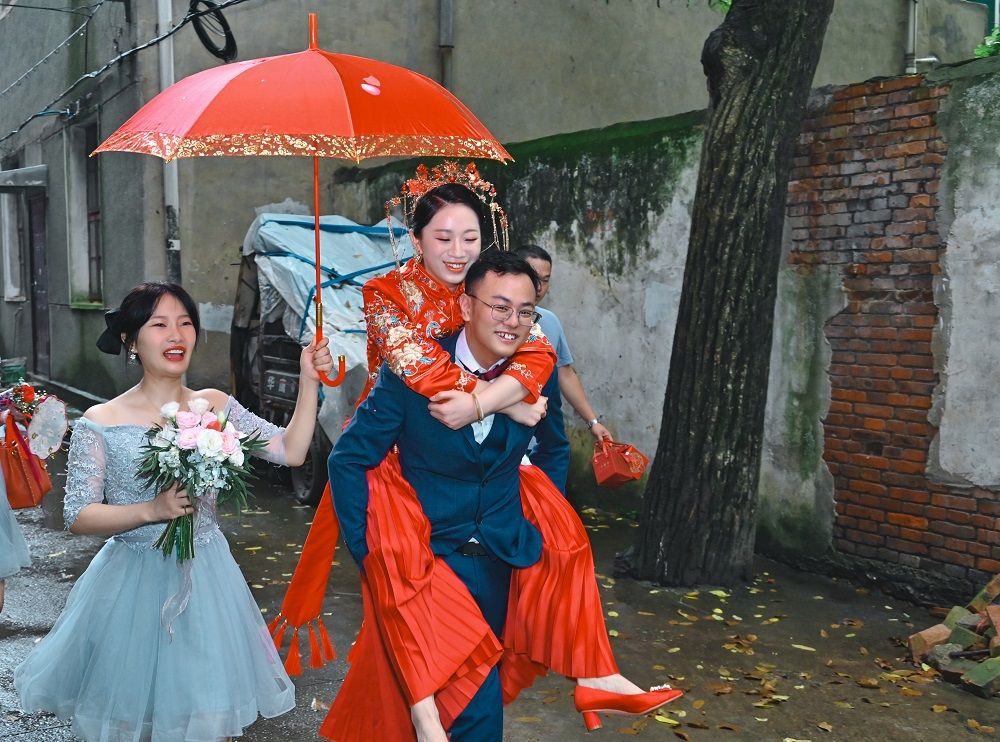 大喜的日子,遇到下雨也开开心心,背着新娘子回家喽.