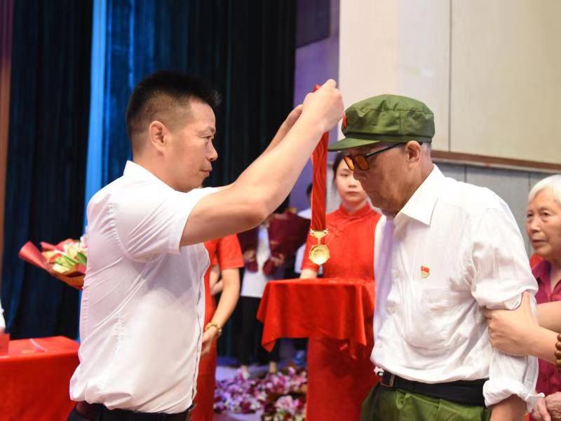 华东交通大学党委副书记、副校长徐长节为老党员颁发“光荣在党50年”纪念章