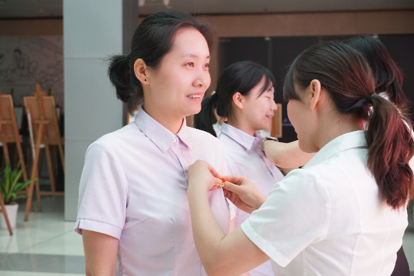 老党员为本月入党的新党员佩戴党徽.严枚廿摄