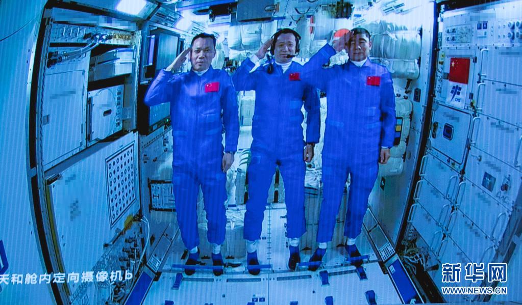6月17日在北京航天飞行控制中心拍摄的进驻天和核心舱的航天员向全国人民敬礼致意的画面。新华社记者 金立旺 摄